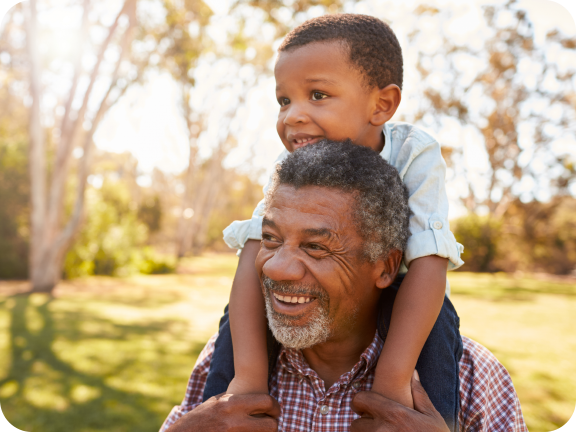 Smiling grandfather carrying his grandson on his shoulders